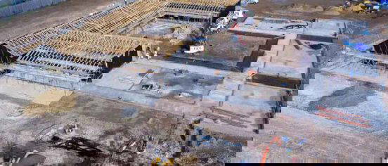 Tracked excavator and dump truck preparing foundation slab and highway-spec roadworks at Henley-on-Thames equestrian centre